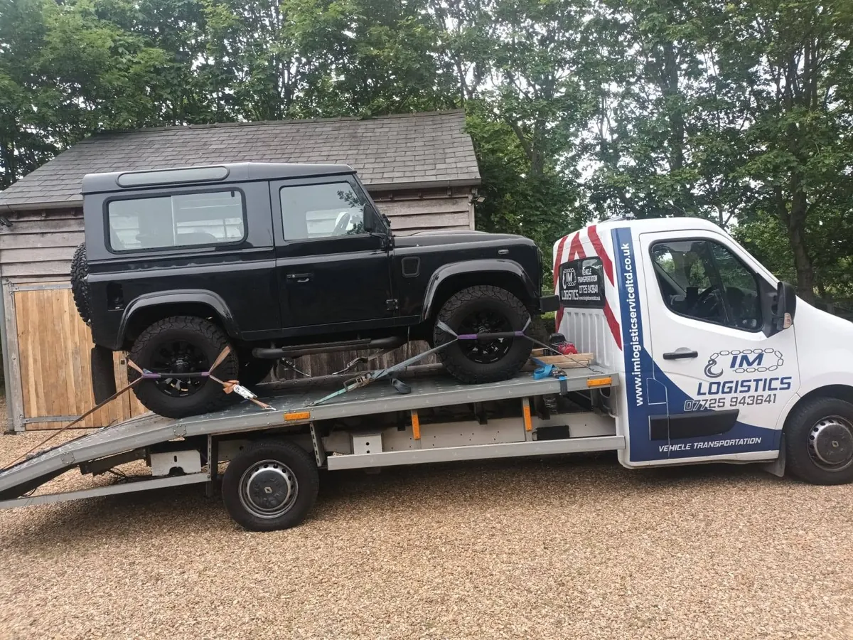Black Land Rover Defender 90 on IM Logistics flatbed — 4x4 recovery specialists
