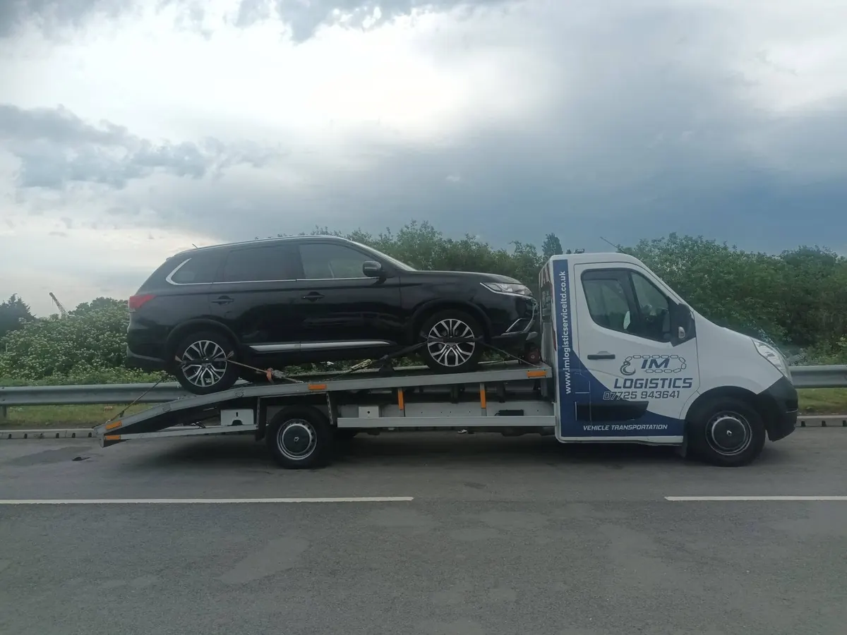 Black Mitsubishi Outlander on IM Logistics flatbed at the roadside — 24/7 motorway recovery