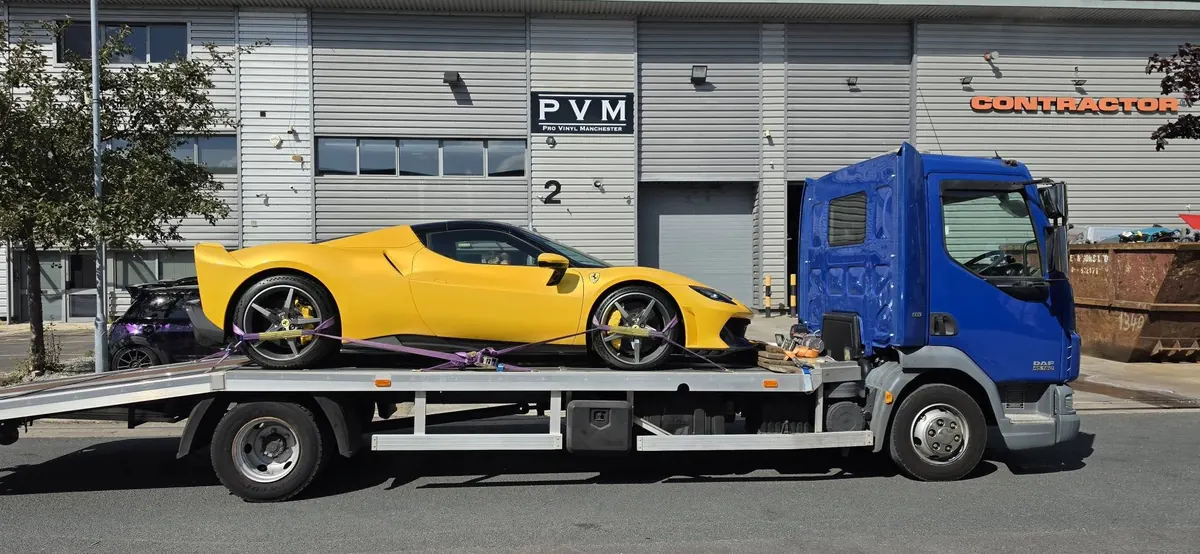 Yellow Ferrari secured on IM Logistics flatbed in Manchester — prestige sports car transport
