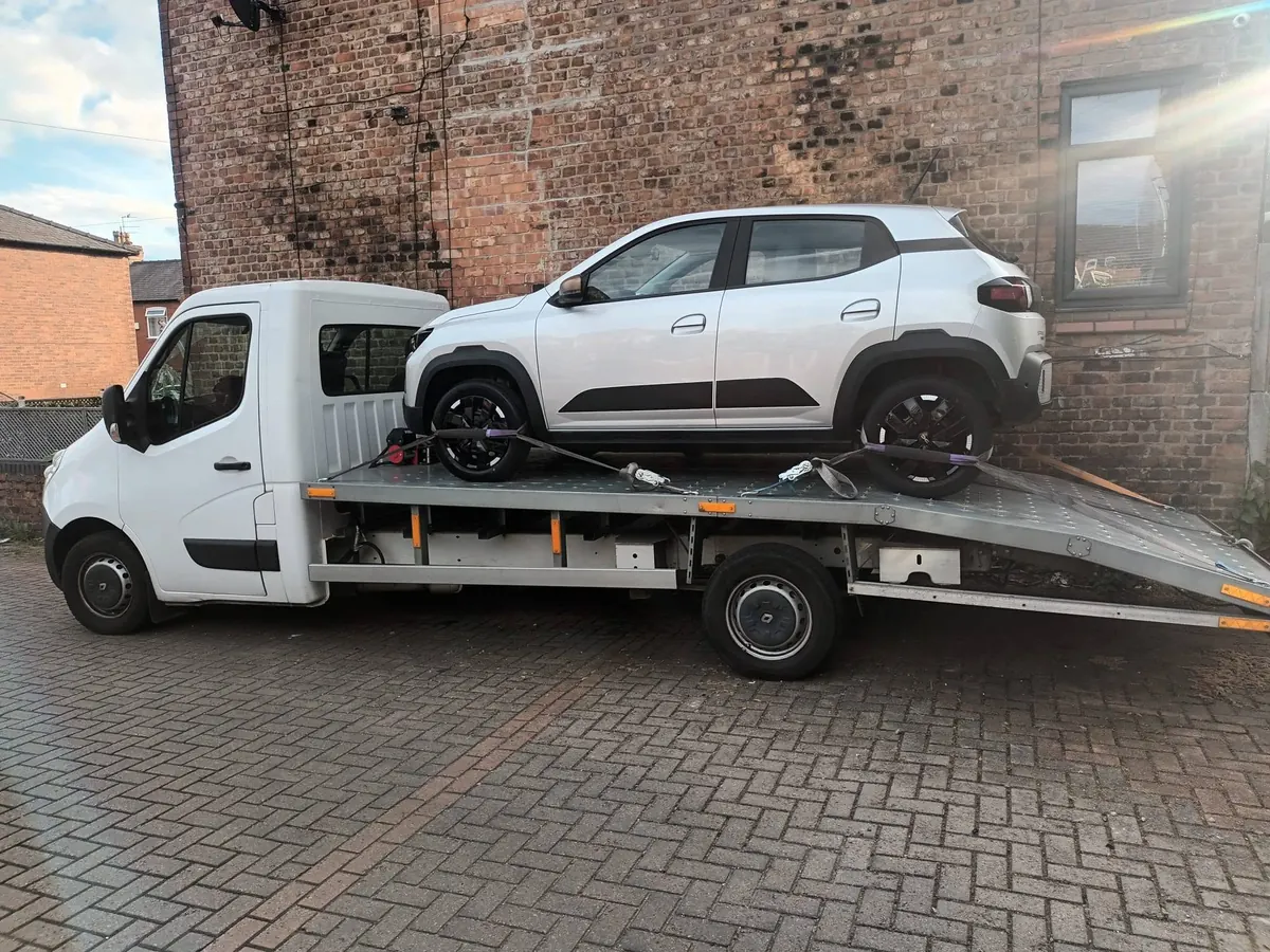 White SUV secured on IM Logistics recovery flatbed — vehicle transportation across the UK